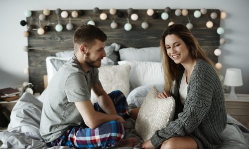 Cheerful couple talking in bed